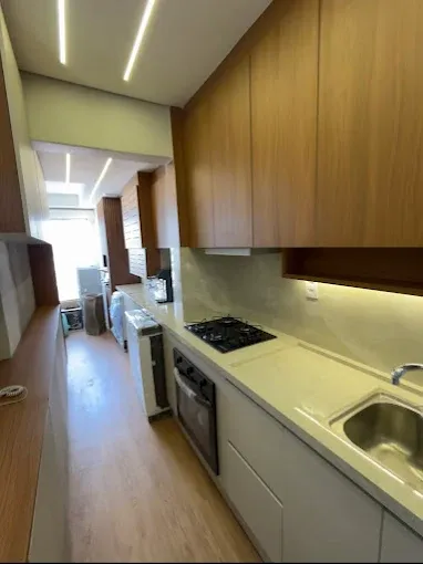 Cozinha planejada em corredor com armários aéreos em madeira